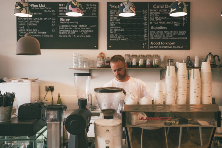 Young man working behind the counter at a coffee shop. Example of a website image.