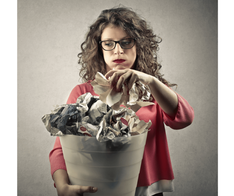 Mom picking up a mess. Trash can filled with wadded up paper.